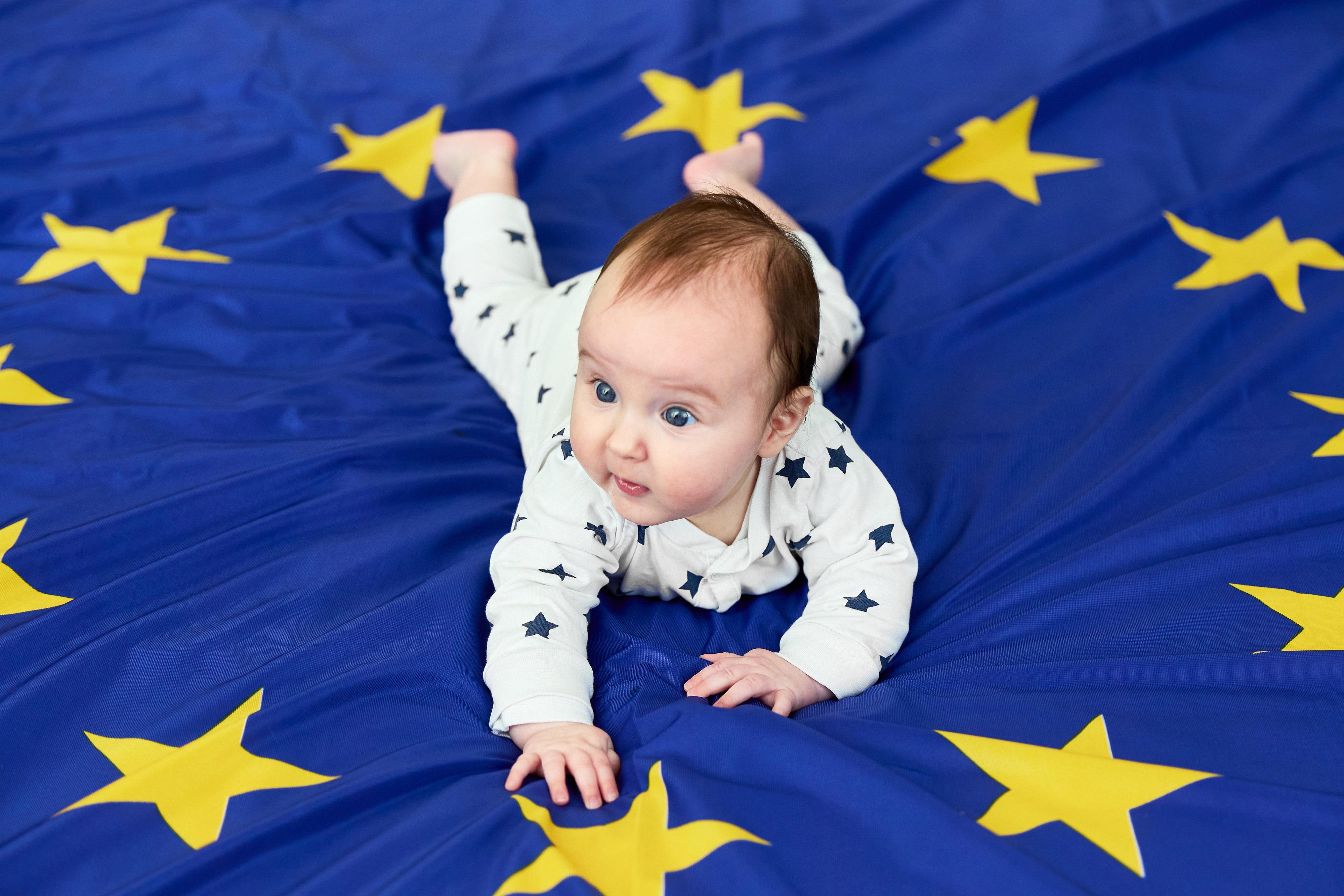 Vauva makoilemassa EU-lipun päällä.